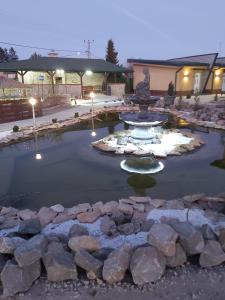 a fountain in a pond in a yard at night at Filigran in Palić