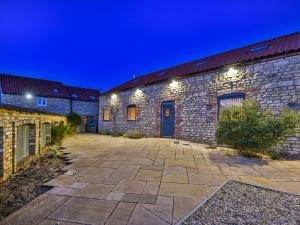 a stone building with a courtyard at night at Hayloft in Lincoln