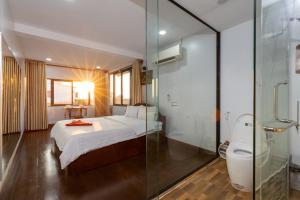 uma casa de banho com uma cama, um chuveiro e um WC. em Damnak Phnom Krom Homestay em Phumĭ Rœssei Lŭk