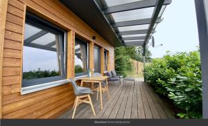 a deck with a table and chairs on a house at Sommerhäuschen in Rheinsberg +13 photos