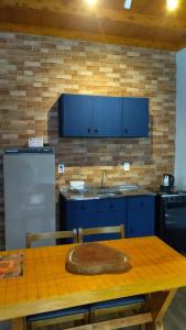 kuchnia z niebieskimi szafkami i drewnianym stołem w obiekcie Casa Kafka - Bio Cult w mieście Campo Alegre