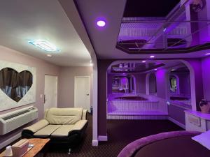 South Amboy的住宿－畫廊假日汽車旅館，紫色的房间,配有一张沙发和一张床