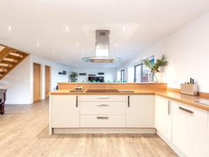 a kitchen with white cabinets and wooden counter tops at Hideaway in Lincoln