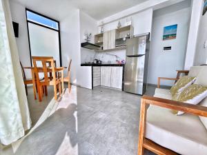 eine Küche und ein Wohnzimmer mit Tisch und Stühlen in der Unterkunft VISTA LINDA BUNGALOW para 4 personas Punta Veleros in Los Órganos + 17 Fotos