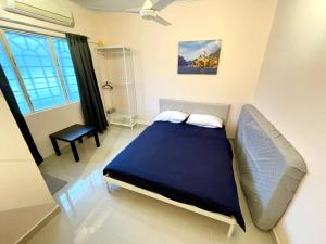 een slaapkamer met een blauw bed en een raam bij 6-12pax The Premium House - The Heart Of Sunway in Petaling Jaya