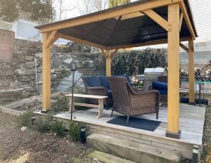 a wooden gazebo with two chairs and a table at Luxury Suite with water view - 2 mini bedrooms in Greenwich +8 photos