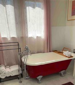 a red bath tub in a bathroom with a window at 2 mini bedrooms with water view 