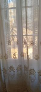 een raam met witte gordijnen en de zon schijnt er doorheen bij ''Dei Vecchi'' apartment in Kerkyra in Corfu-stad