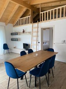 uma sala de jantar com uma mesa de madeira e cadeiras azuis em Cabanele Olena em Borsa