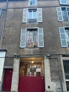 un edificio con una puerta roja y ventanas en Home prestige 21, en Dijon