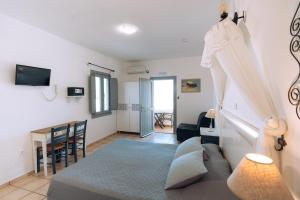 uma sala de estar com uma cama, uma mesa e cadeiras em Aspa Villas em Oia