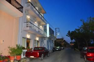 a red truck parked in front of a building at Nora Hotel in Sitia