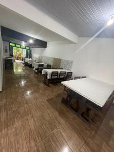 トラマンダイにあるHotel Central Praiaのテーブルと椅子が備わる広い客室です。