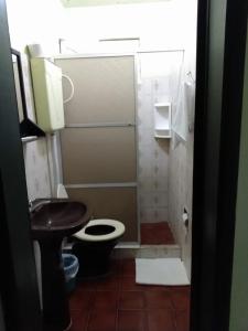 ein kleines Bad mit WC und Waschbecken in der Unterkunft Hotel Central Praia in Tramandaí
