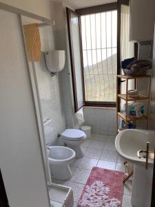 a bathroom with a toilet and a sink and a window at La dimora di Titiro in Cetraro