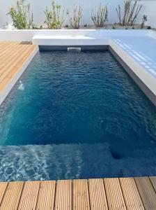 una piscina de agua azul con terraza de madera en Casa Monda- Comporta, en Carvalhal