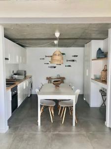 cocina blanca con mesa blanca y sillas en Casa Monda- Comporta, en Carvalhal