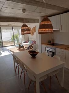 a kitchen with a table and chairs and two pendant lights at Casa Monda- Comporta in Carvalhal +9 photos