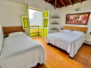 een slaapkamer met twee bedden en een balkon bij HOTEL MONTE VERDE in Concordia