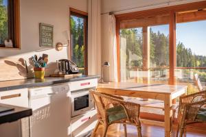 a kitchen with a table and chairs and a large window at Myra Canyon Lodge in Kelowna