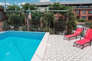 a patio with two chairs and a swimming pool at My Georgian village in Sagarejo