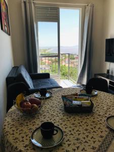 una sala de estar con una mesa con un bol de fruta. en Apto Beira Mar Grande Floripa, en Palhoça