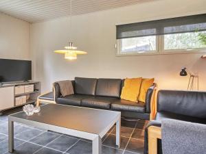 a living room with a couch and a table at 4 person holiday home in Aakirkeby in Vester Sømarken