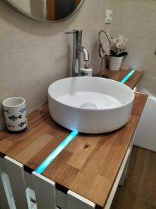 a bathroom with a white sink on a wooden counter at Appartamenti MiNuMa Tropea in Tropea