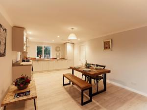 uma cozinha e sala de jantar com uma mesa de madeira e cadeiras em Tor Cottage em Exeter