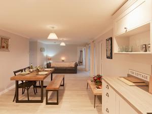 a kitchen and living room with a table and a bed at Tor Cottage in Exeter