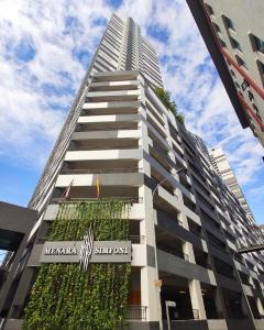 ein hohes Gebäude mit nebenstehenden Pflanzen in der Unterkunft Eshue Designer Suites @ Simfoni Towers in Cheras
