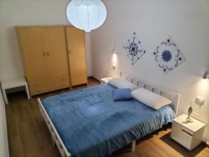 - une chambre avec un lit et une couverture bleue dans l'établissement Appartamenti MiNuMa Tropea, à Tropea