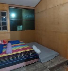 Habitación pequeña con cama y ventana en Delta Island Camping Ground en Sumedang