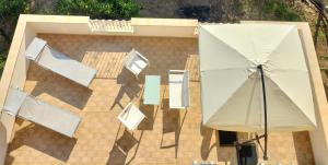 Elle offre une vue sur la terrasse dotée d'un parasol et de chaises. dans l'établissement Appartamenti MiNuMa Tropea, à Tropea