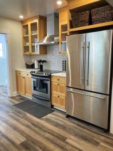 a kitchen with a stainless steel refrigerator and wooden cabinets at Centrally located, family and furry friendly fun! in Yakima