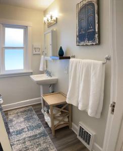 La salle de bains est pourvue d'un lavabo, d'un miroir et de serviettes. dans l'établissement Centrally located, family and furry friendly fun!, à Yakima