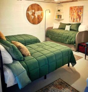 a living room with two beds and a green ottoman at Centrally located, family and furry friendly fun! in Yakima