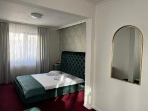 um quarto de hotel com uma cama e um espelho em Eden Boutique Accommodation em Bucareste