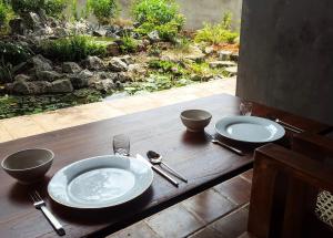 a wooden table with two plates and silverware on it at Takimi Mini Villa in Wellawaya