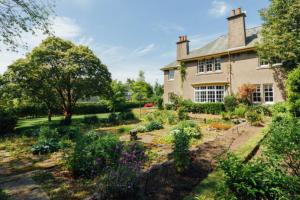 Una casa grande con un jardín enfrente. en Newholme House, en Stirling
