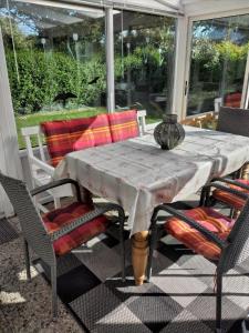 una mesa y sillas en un porche cubierto en Gemütliches Ferienhaus in Oudesluis mit Terrasse, Grill und Garten, en Oudesluis