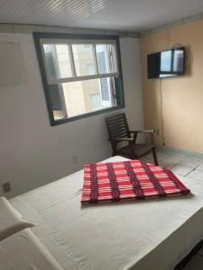 特拉曼達伊的住宿－Hotel Central Praia，一张床上的红色毯子,放在一个房间里