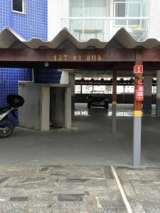 un estacionamiento con un coche estacionado bajo un edificio en Apartamento em Guarapari, en Guarapari