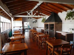 ビージャ・ヘセルにあるHosteria San Marcosの木製のテーブルと椅子、暖炉のあるレストラン