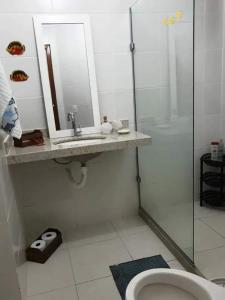 y baño con lavabo, ducha y aseo. en Apartamento em Guarapari, en Guarapari