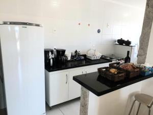 a kitchen with a stove and a counter top at Apartamento em Guarapari in Guarapari