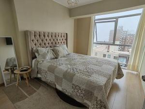 una camera con un grande letto e una grande finestra di Ocean Apartments a Lima