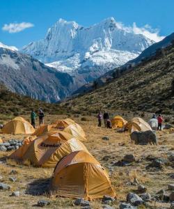 a group of tents in a field with a mountain at Hotel Valery II in Huaraz