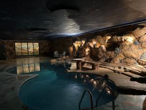 einen Pool in einem Zimmer mit einer Steinmauer in der Unterkunft شاليهات ليالي زين الشرف 1 in Ta'if