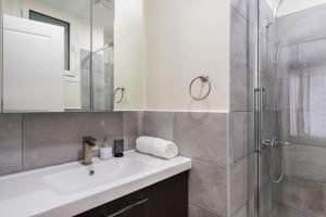 um banheiro branco com uma pia e um chuveiro em Athena's Nest- *best Location* A/C +HEAT! em Atenas